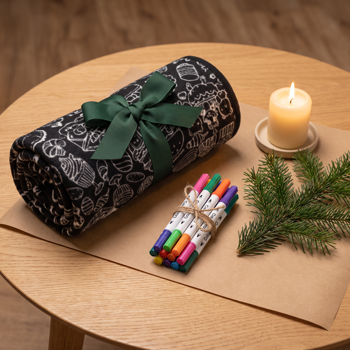 Decke als Geschenk mit grünem Band und Stiften